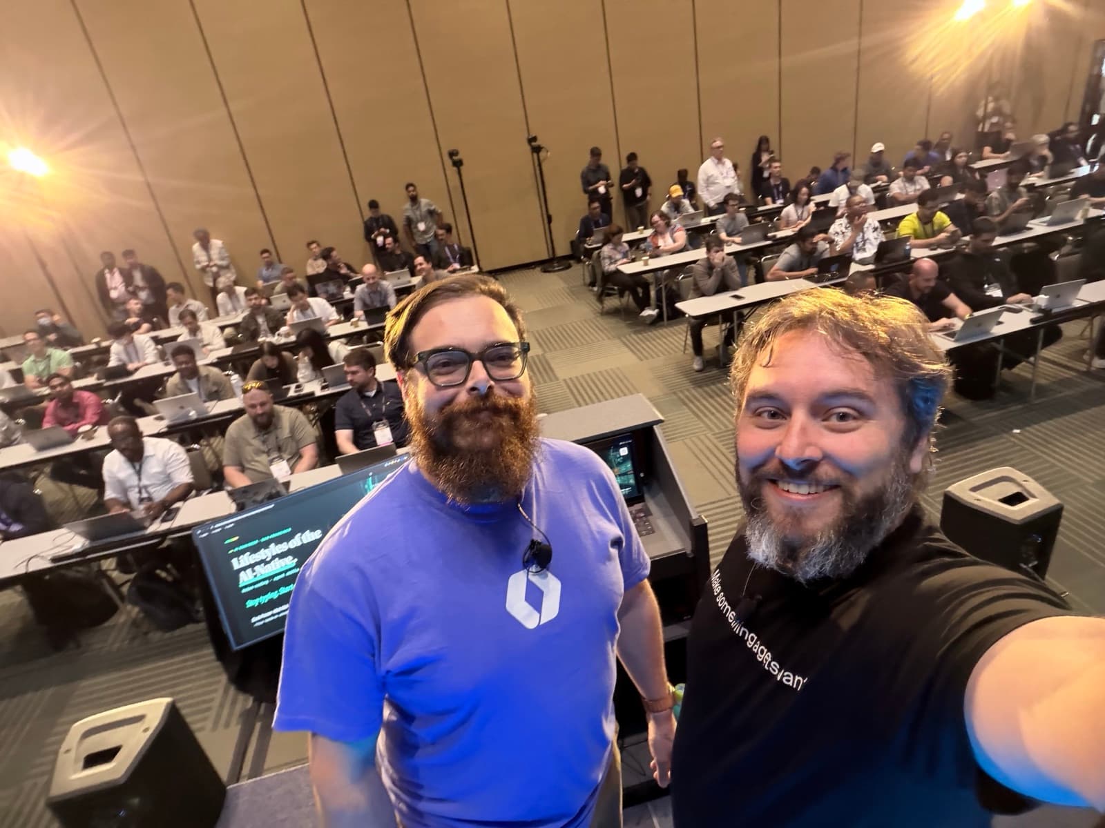 Zack Proser and Nick Nisi in front of the full workshop room at the AI Engineer World's Fair, rows of attendees at laptops behind them