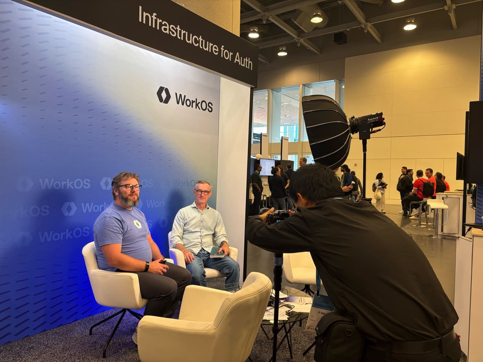 Filming an interview at the WorkOS booth at the AI Engineer World's Fair, with studio lighting and the Infrastructure for Auth backdrop