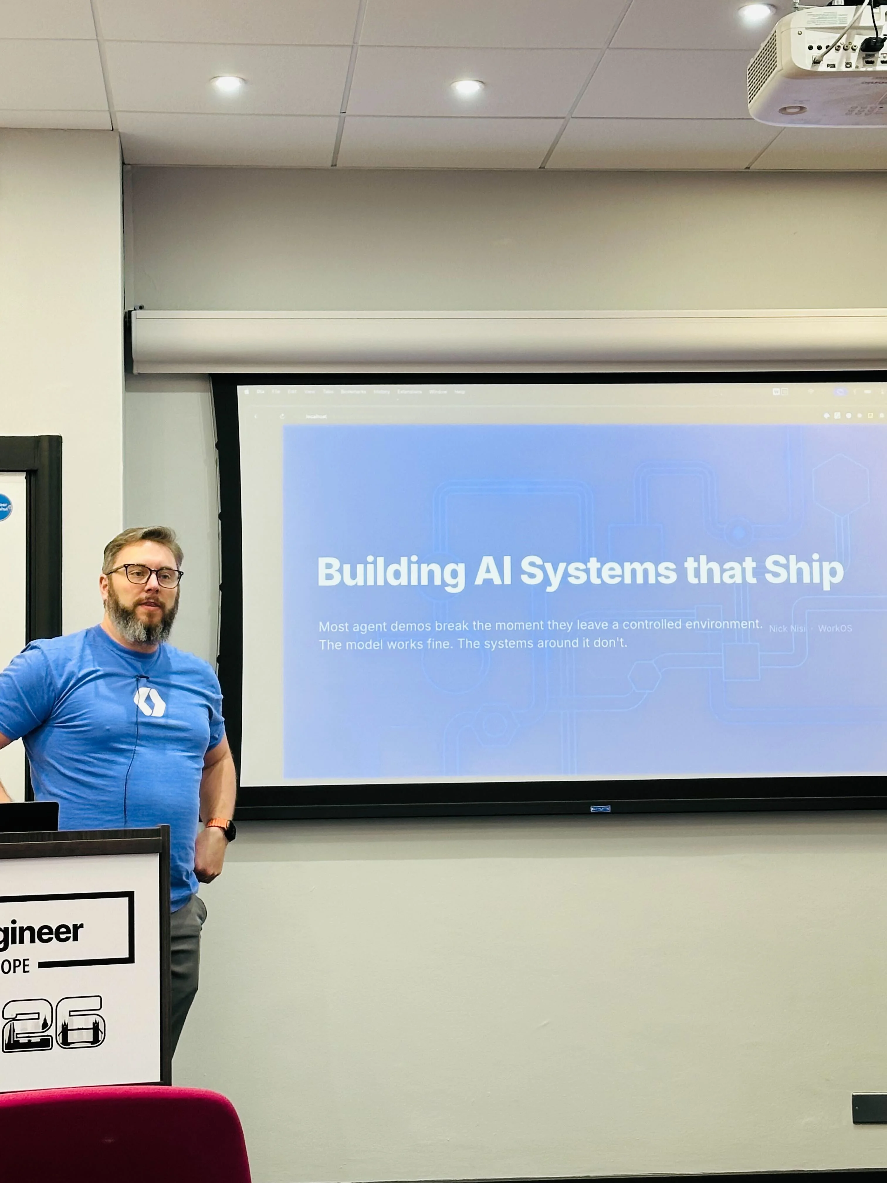 Nick Nisi presenting 'Building AI Systems that Ship' on stage at AI Engineering London