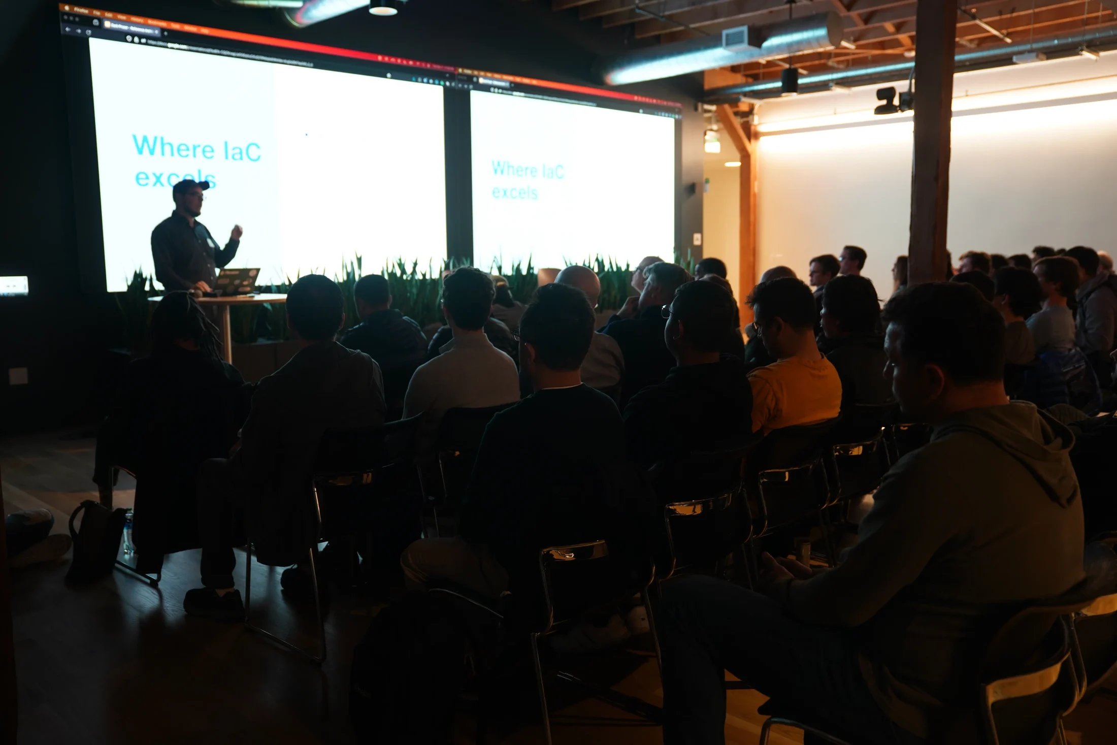 Zack silhouetted against a presentation screen while addressing the a16z audience.