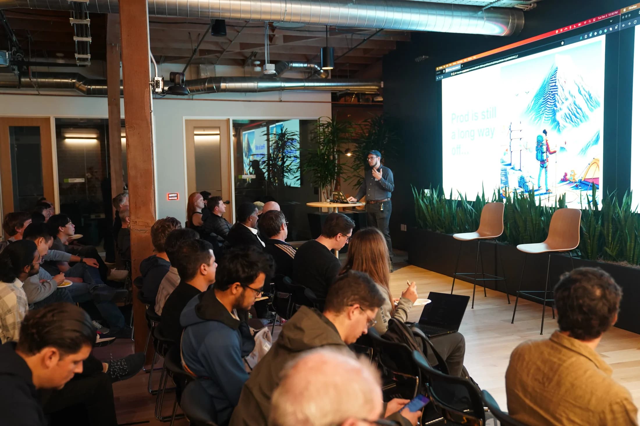 Zack presenting to a seated audience in the a16z event space.