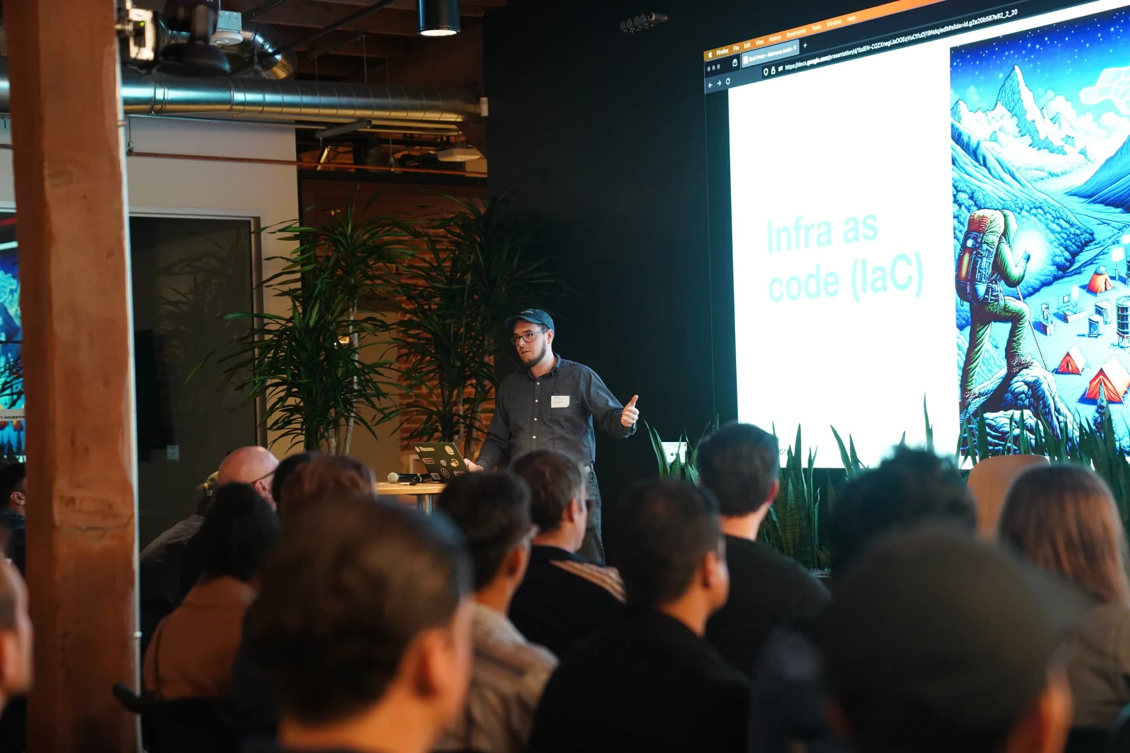 Zack speaking beside a mountain illustration about moving from prototype to production.