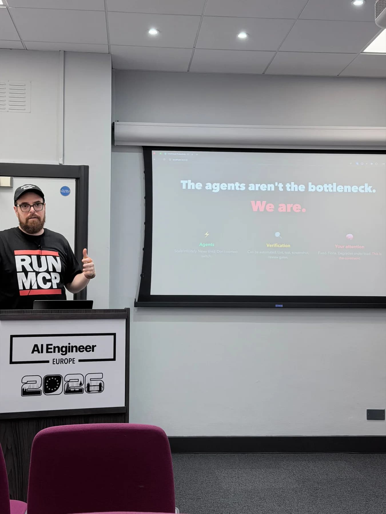 Zack beside a slide reading: The agents aren’t the bottleneck. We are.
