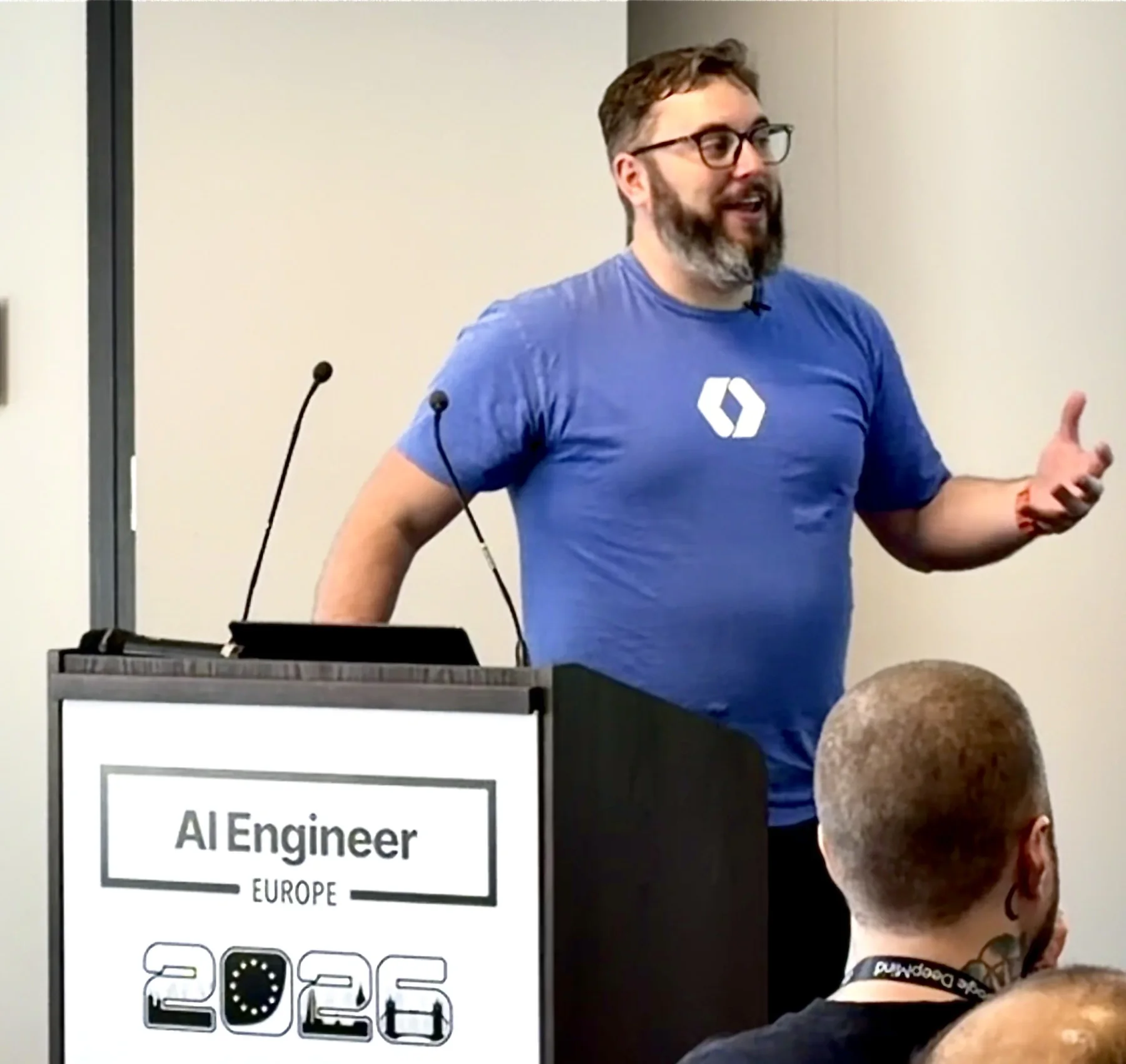 Zack speaking and gesturing at the AI Engineer Europe lectern.