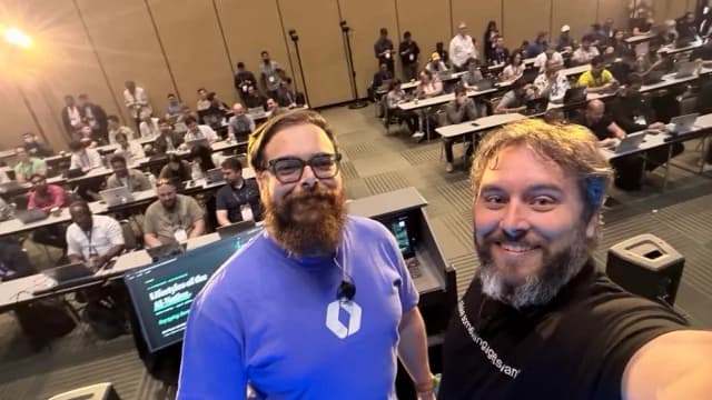 Zack and Nick taking a photograph from the stage, with the workshop audience behind them.