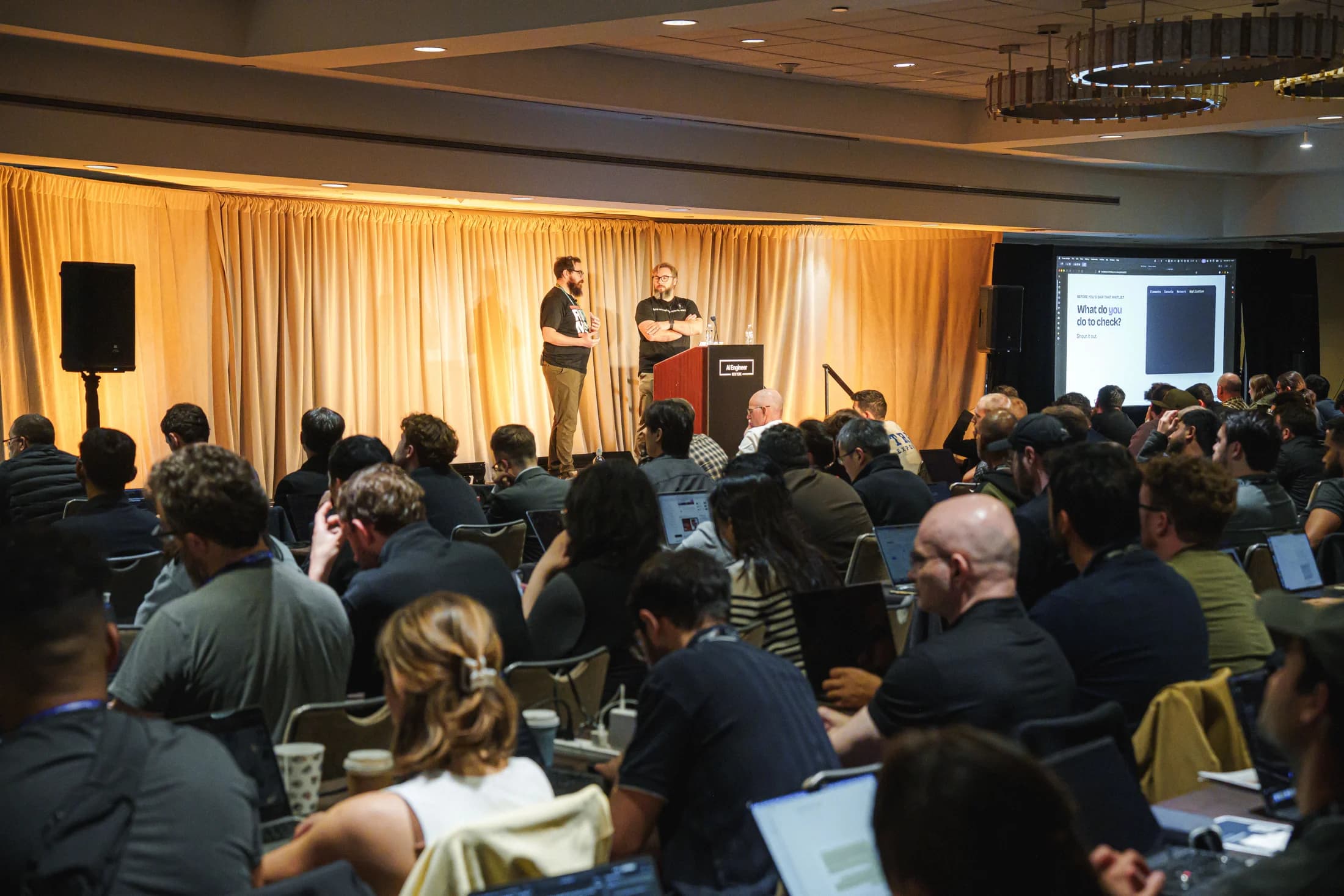 Zack and Nick teaching a packed workshop at AI Engineer New York, with attendees working on laptops.