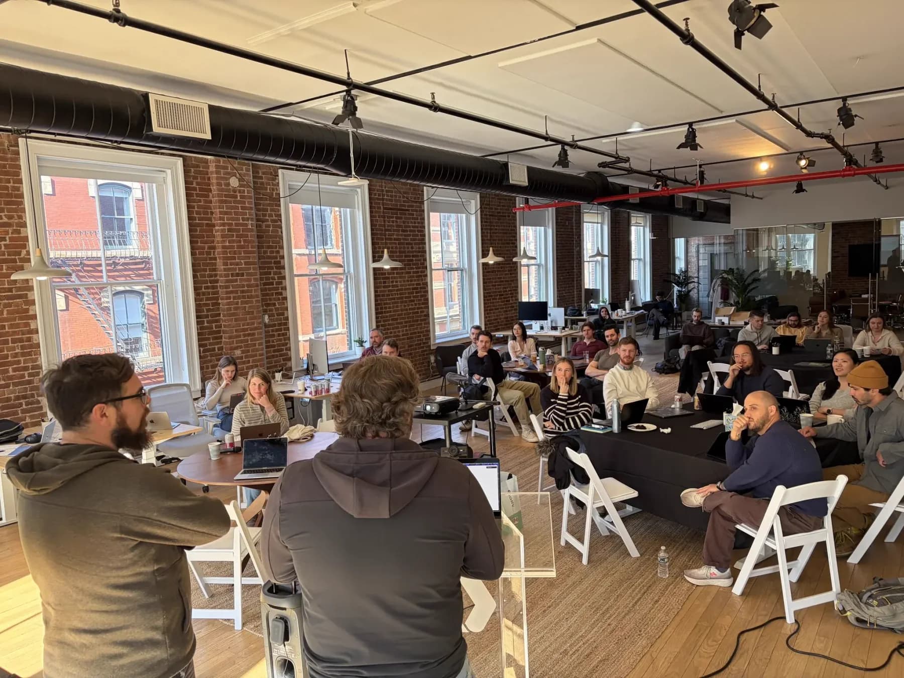 Colleagues gathered around tables for a WorkOS team training session.