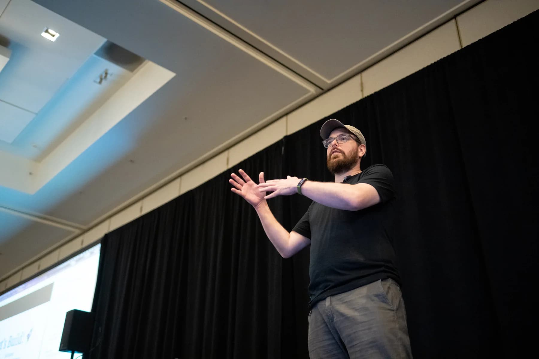 Zack gesturing to the room while teaching AI workflows and Mastra on stage.